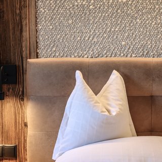 Zimmerdetail Kopfkissen und Altholzwand