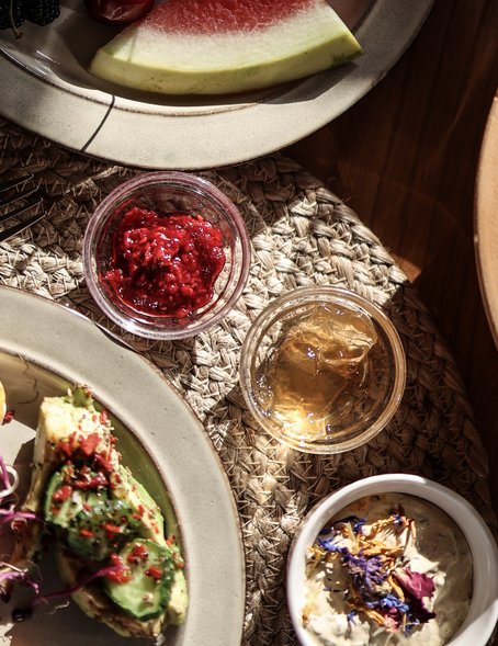 Schön gedeckter Frühstückstisch mit hausgemachten Marmeladen in der Morgensonne 