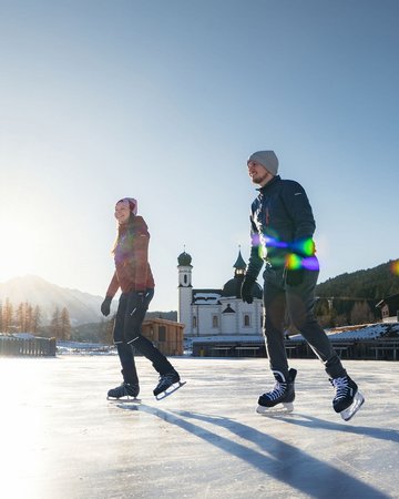 Paar beim Eislaufen vor dem Seekirchl in Seefeld 