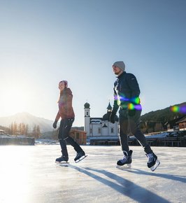 Paar beim Eislaufen vor dem Seekirchl in Seefeld 
