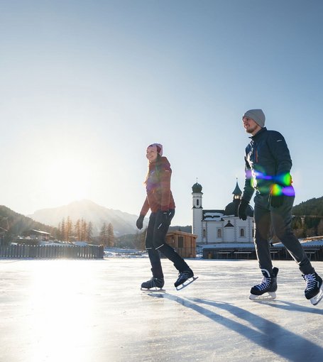 Paar beim Eislaufen vor dem Seekirchl in Seefeld 