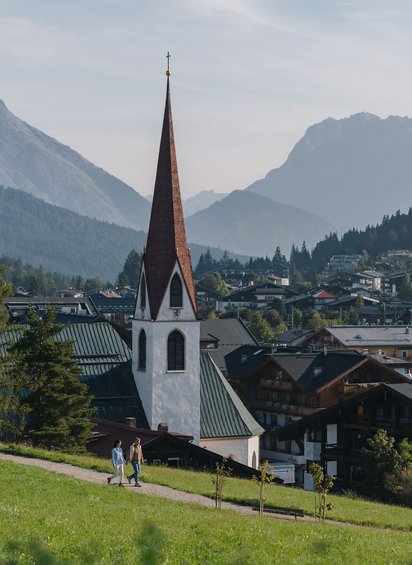 Paar in der Region Seefeld auf dem Pfarrhügel mit Blick auf die Kirche 