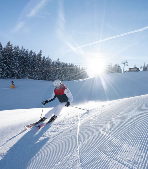 Skifahrer auf sonniger Piste mit Blick auf das Karwendel