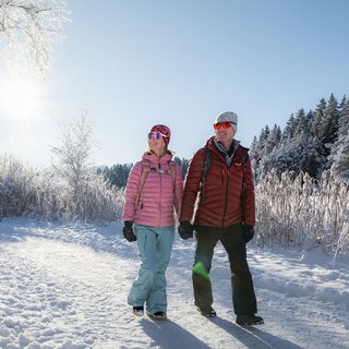 Paar beim Winterwandern auf verschneitem Weg bei Seefeld