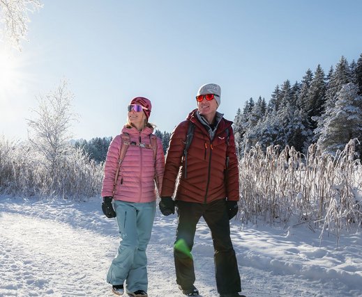 Paar beim Winterwandern auf verschneitem Weg bei Seefeld